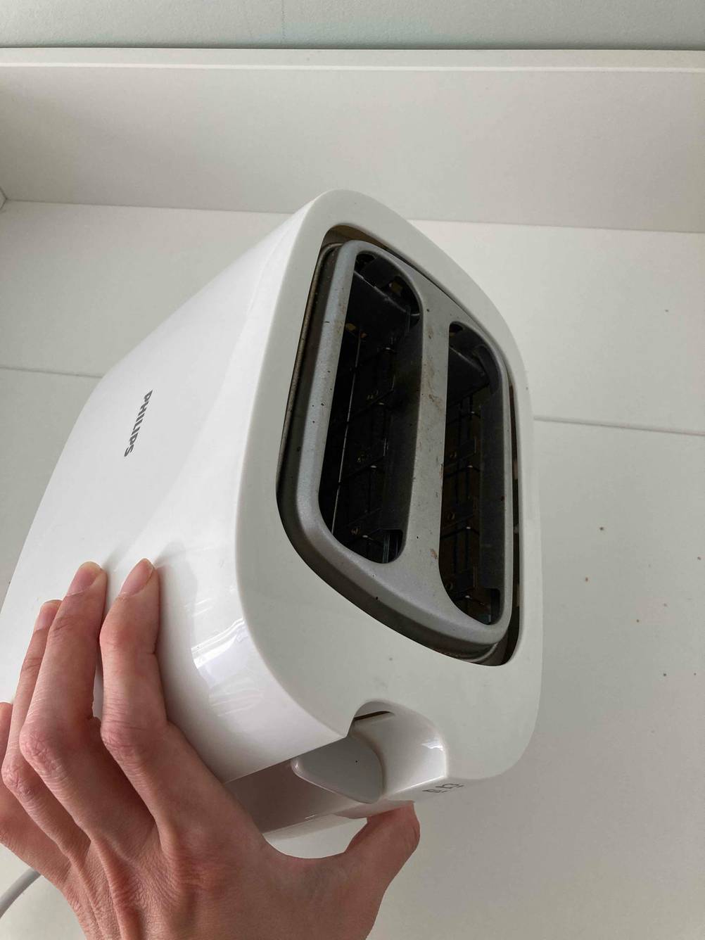 Eine Hand hält einen Philips-Toaster im Test mit Blick auf die obere Seite.