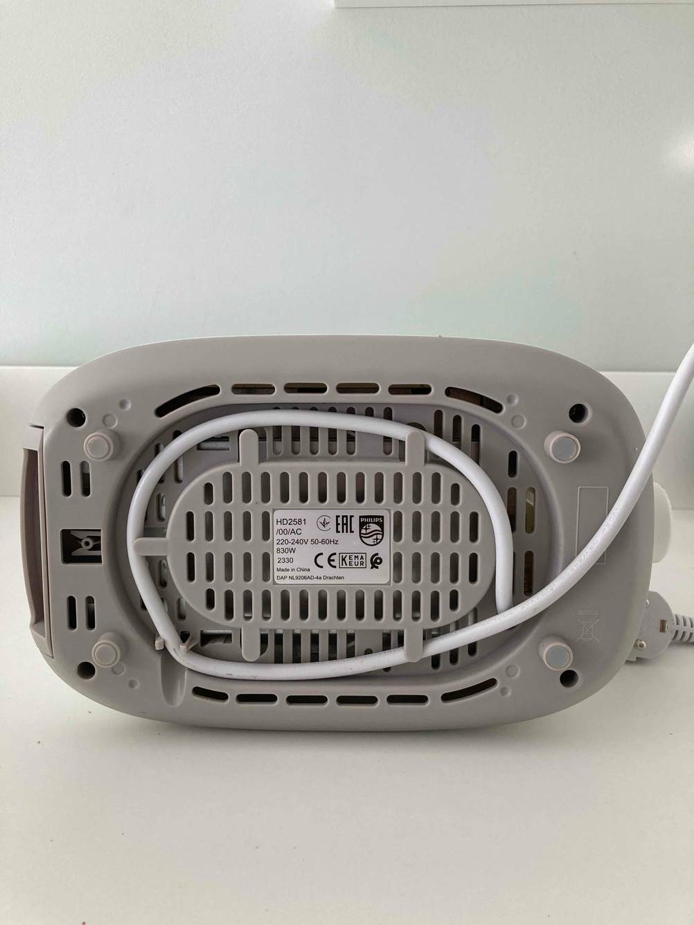 Auf der Unterseite eines getesteten Philips-Toasters sind Typenschild, Kabelaufbewahrung und Saugnäpfe.