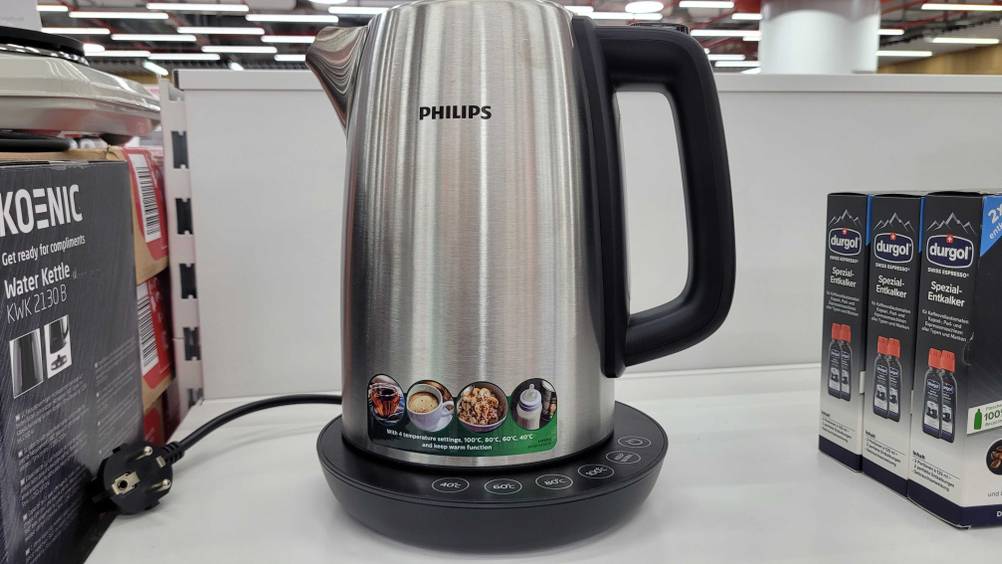 Auf einem weißen Verkaufsregal steht zwischen anderen Produkten ein getesteter Philips-Wasserkocher.