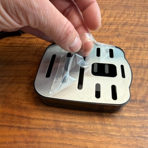 Eine Folie wird von der Abtropfschale der Philips Water Station abgezogen.