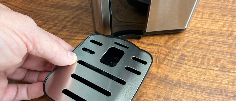 Eine Hand befestigt die Abtropfschale an der Philips Water Station.