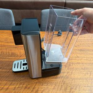 Eine Hand hebt den Wassertank der Philips Water Station hoch.