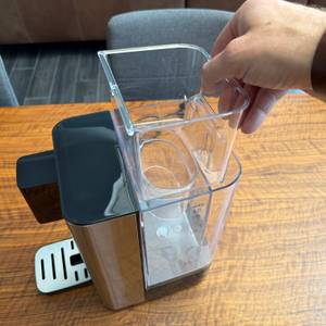 Eine Hand nimmt den Einsatz für einen Filter aus dem Wassertank der Philips Water Station.