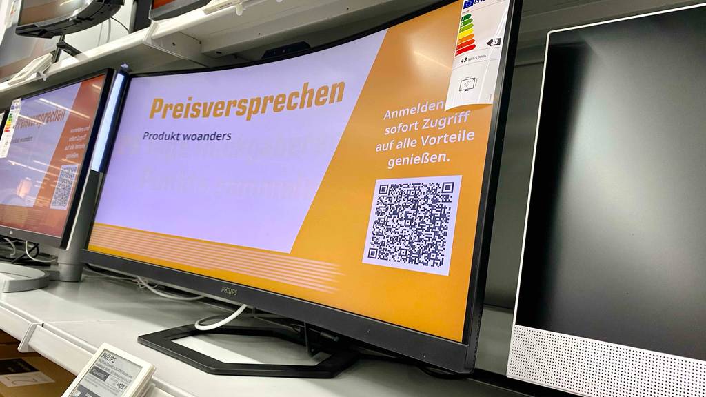 WQHD-Monitor im Test: Ein eingeschaltetes Gerät mit Werbeanzeige von rechts schräg unten betrachtet.