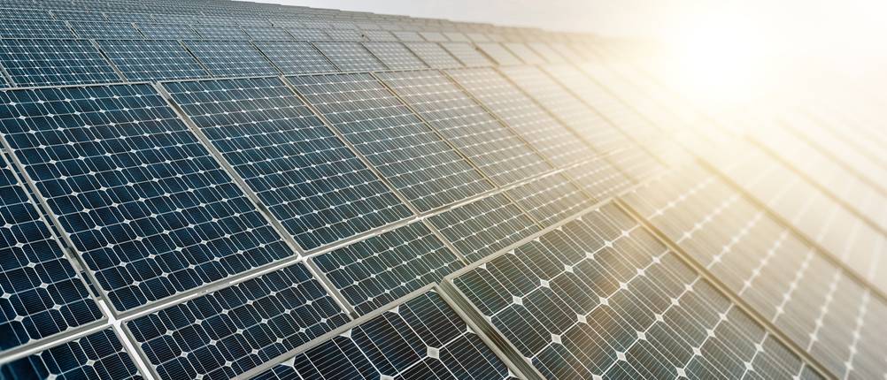 Einige Solarmodule werden von der Sonne angeleuchtet.