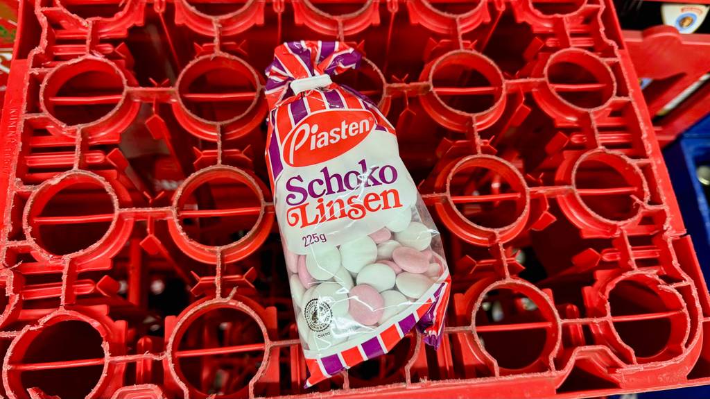 Eine Packung Schokolinsen liegt zum testen auf einer umgedrehten Getränkekiste.