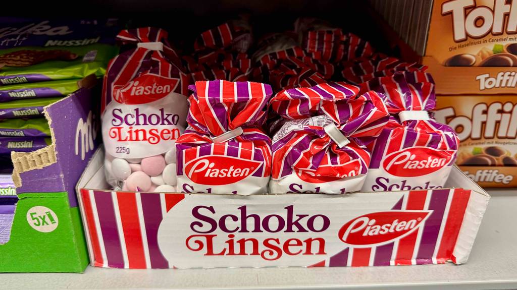 Schokolinsen im Test: Mehrere Packungen stehen hinter- und nebeneinander zwischen anderen Süßigkeiten.