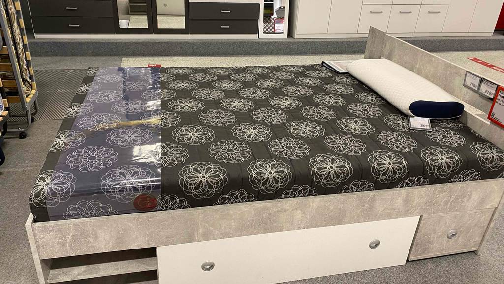Matratze 140x200 im Test: Eine Matratze liegt auf einem Bett, das in einem Verkaufsraum steht.