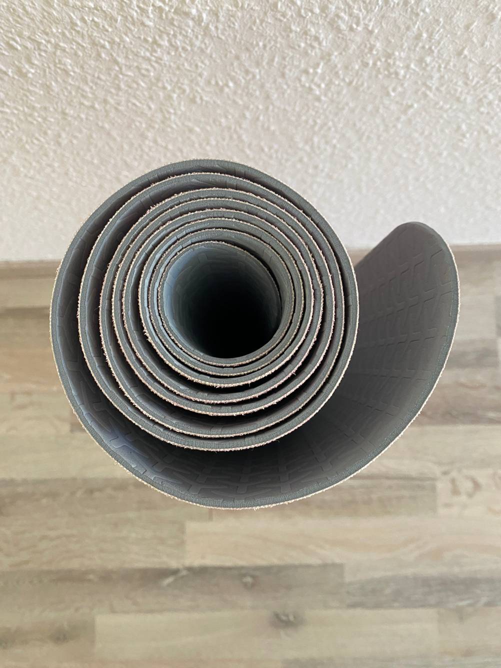 Yogamatte aus Naturkautschuk getestet: Blick durch eine zusammengerollte Matte, die auf einem Laminatboden steht.