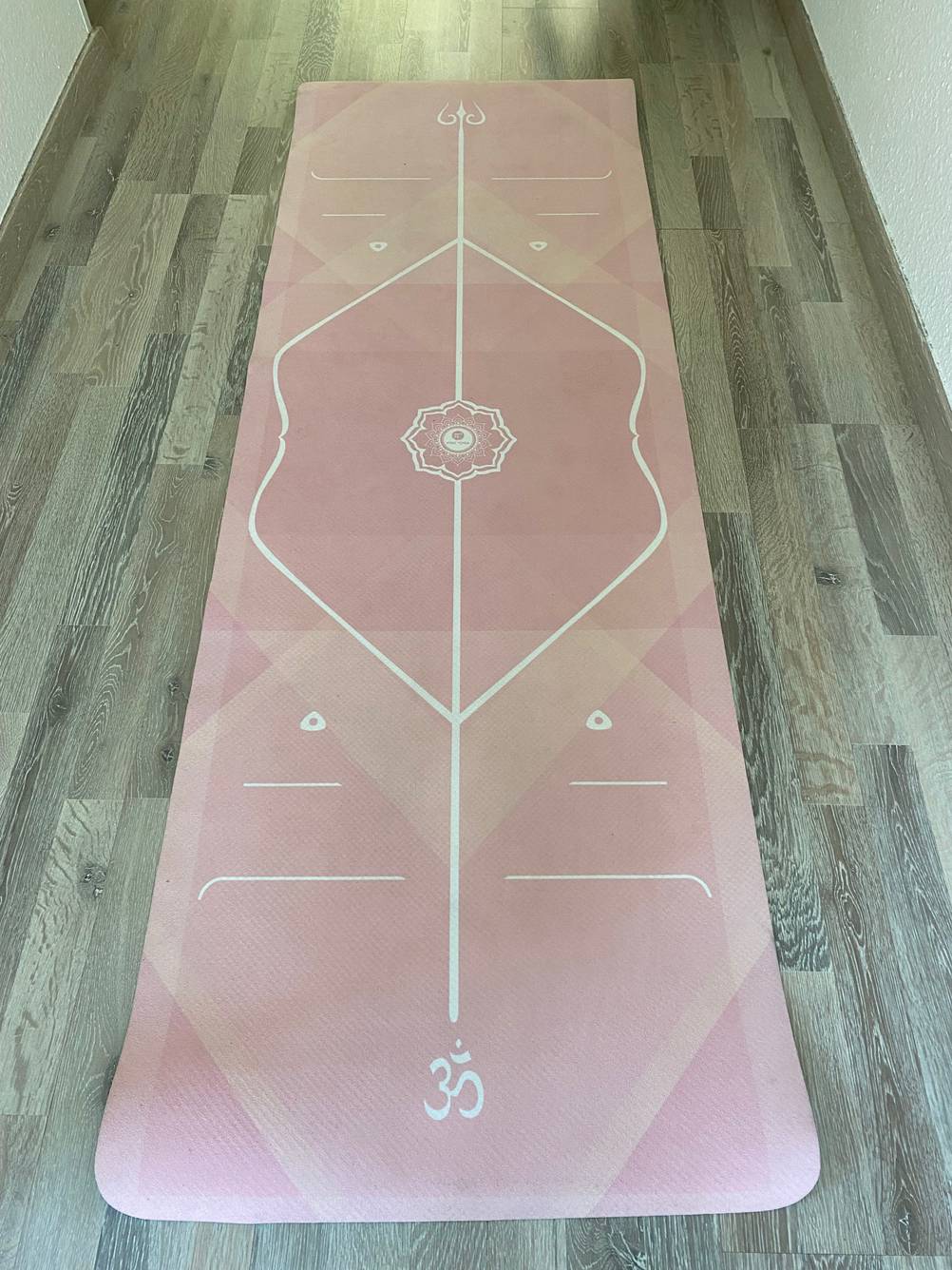 Eine Yogamatte aus Naturkautschuk liegt zum testen ausgerollt auf einem Laminatboden.