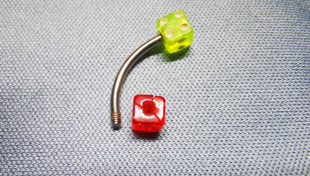Piercing-Test: Blick von oben auf ein geöffnetes Piercing im Würfeldesign.