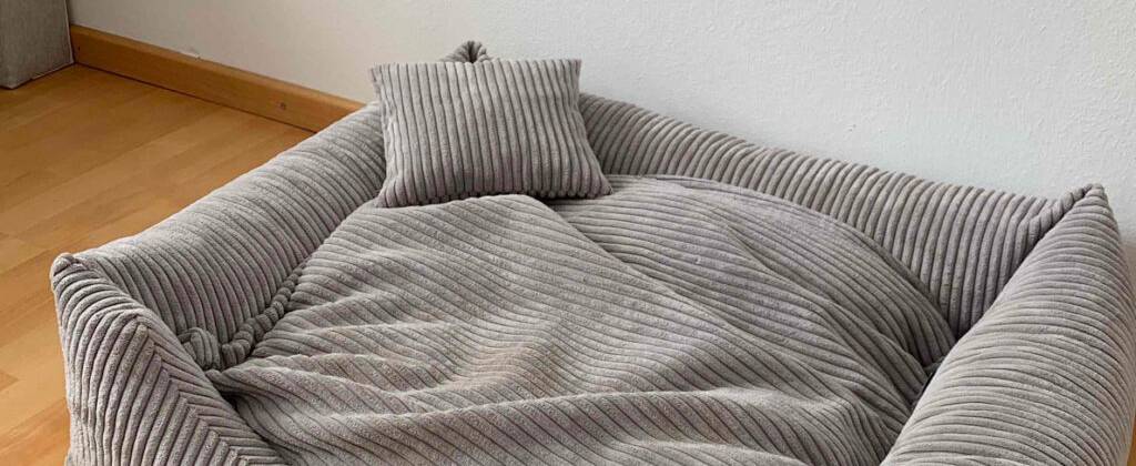 Nahaufnahme der Polsterung und des Kissens eines getesteten Hundebetts in Grau.