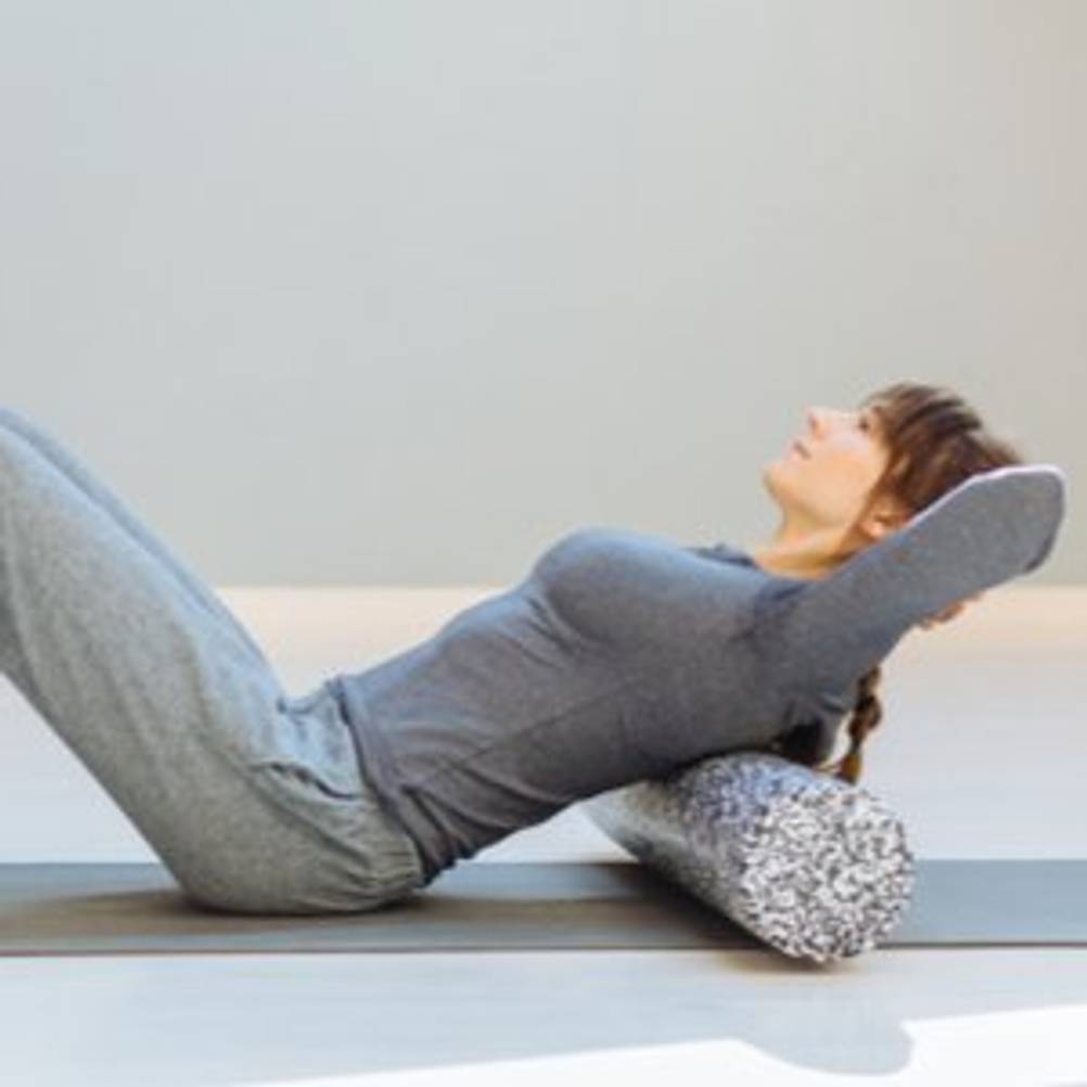 frau entspannt mit pilates-rolle
