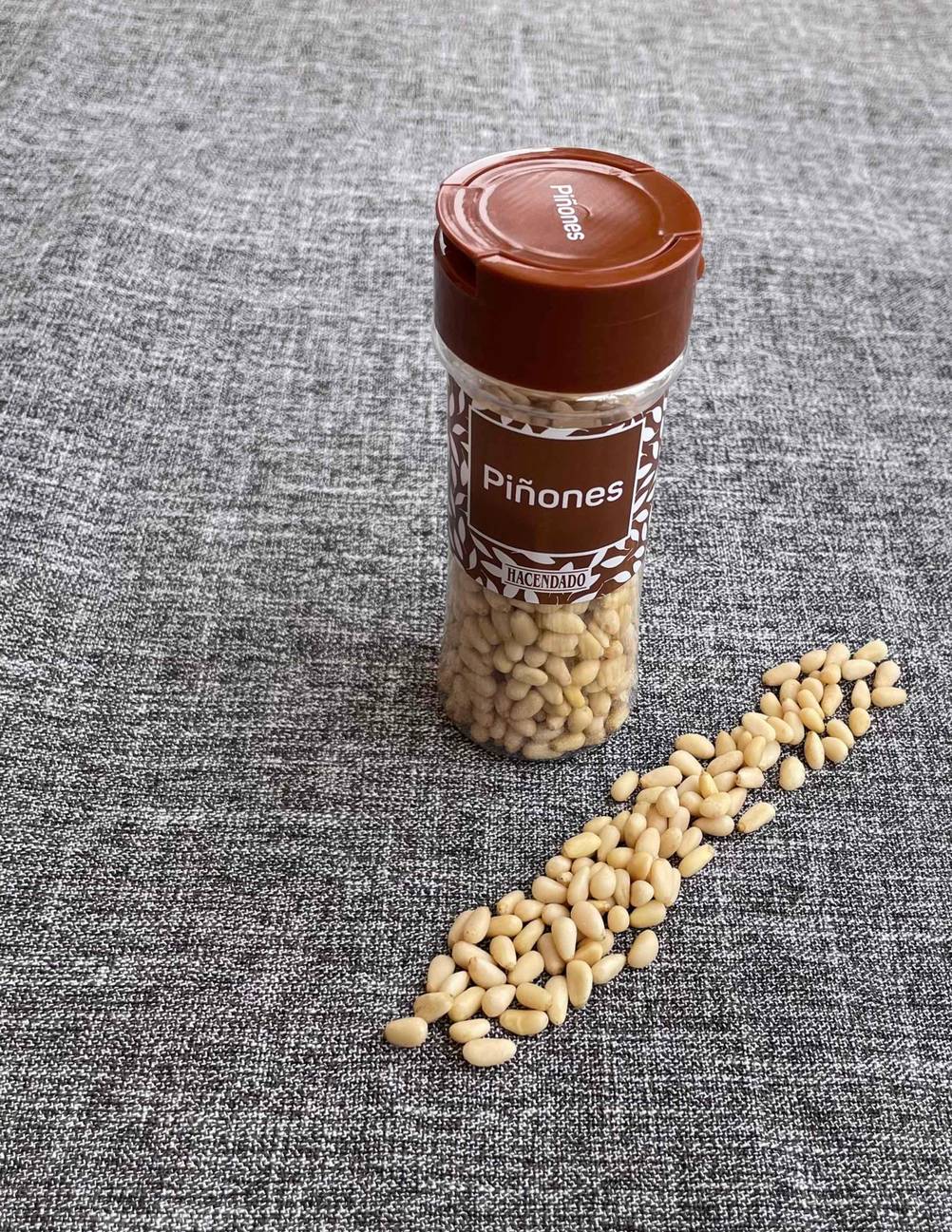 Pinienkerne im Test: Mehrere Pinienkerne befinden sich neben der Verpackung. 