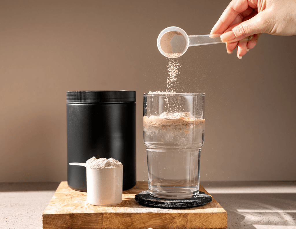 Pinienpollen-Test: Eine Frau gibt Pulver in ein Glas Wasser. 