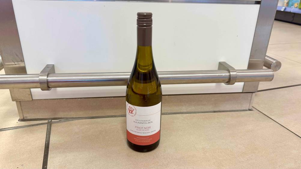 Auf dem Boden steht eine Flasche des getesteten Pinot Noir.