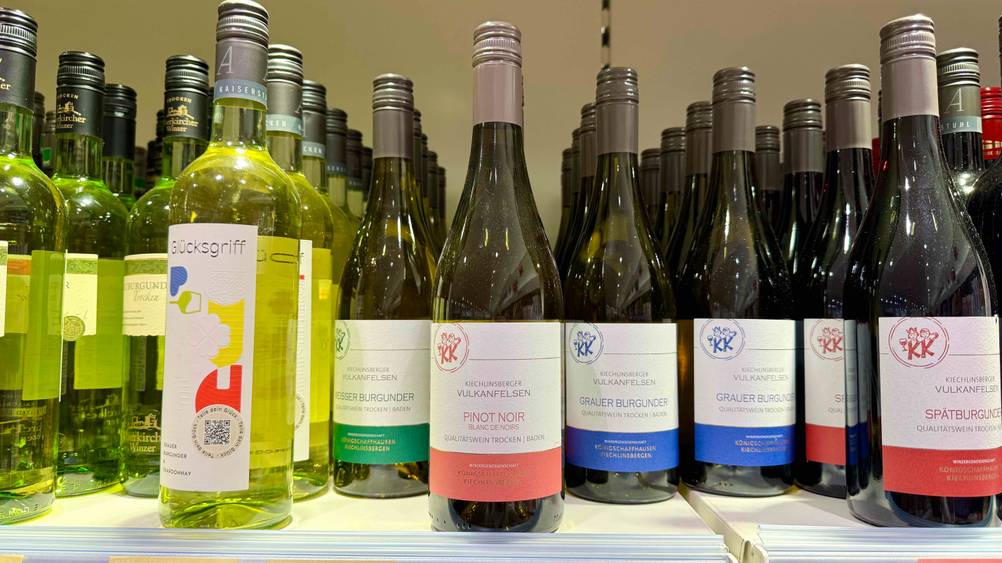 Mehrere Flaschen des Pinot Noir im Test neben anderen Produkten in einem Verkaufsregal.