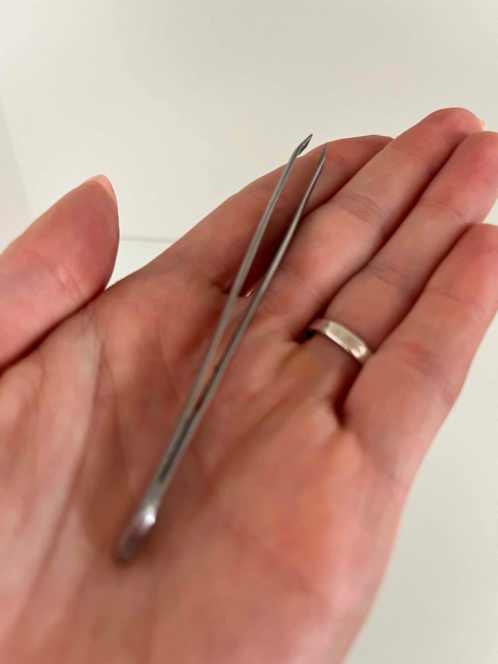 Im Test: silberne Pinzette liegt auf flacher Hand.