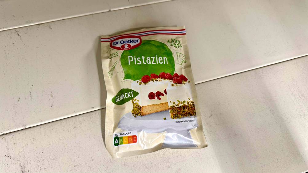 Eine Packung der getesteten Pistazien gehackt liegt auf einem hellen Boden.
