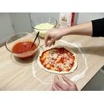 Ein Pizzaboden mit Tomatensoße wird mit Käse bestreut.