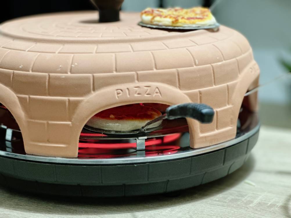 Eine kleine Pizza wird im Pizzaofen von Heidenfeld zubereitet.