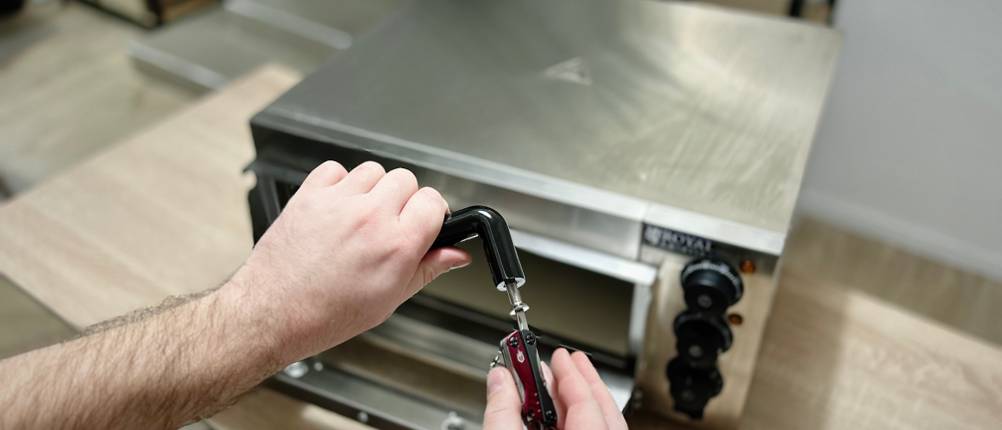 Der Griff wird an den Royal Catering Pizzaofen geschraubt.