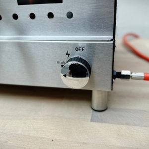 Der Gasregler des Heidenfeld KY019G ist mit einer Zündung und Skala beschriftet. Der Schlauchanschluss für das Gas ist sichtbar. 