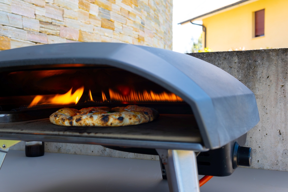 Eine Pizza backt in einem großen Gas-Pizzaofen.
