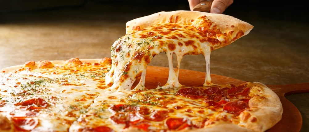 Salamipizza auf einem Holzbrett.