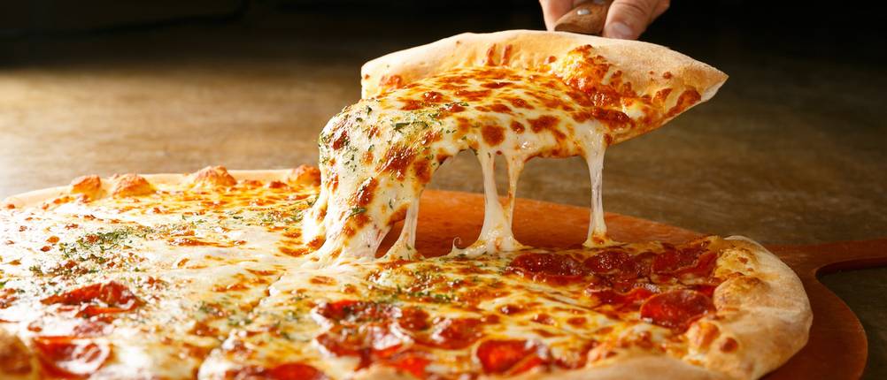 Salamipizza auf einem Holzbrett.