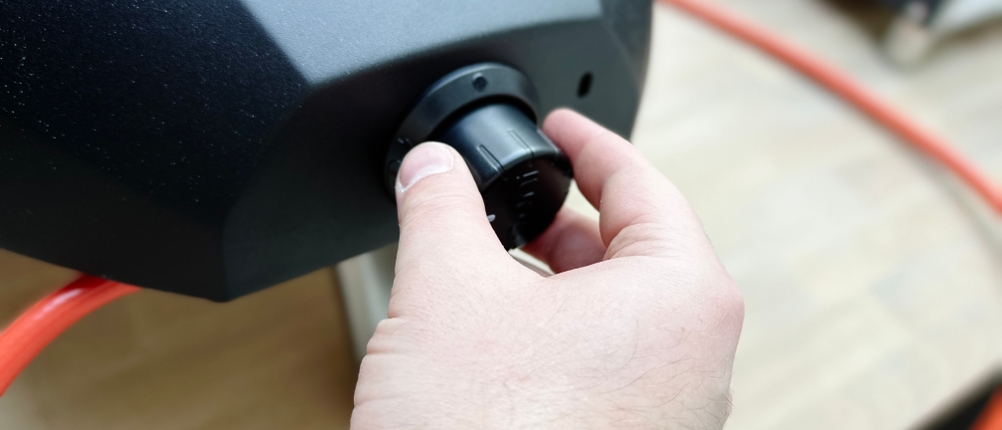 Ein Nutzer dreht den Temperaturregler des Ooni Koda 12. Der schwarze Drehknopf sitzt am Gehäuse des Pizzaofens.