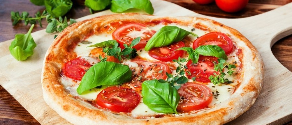 Eine fertige Pizza lieft auf einem Holzschieber.