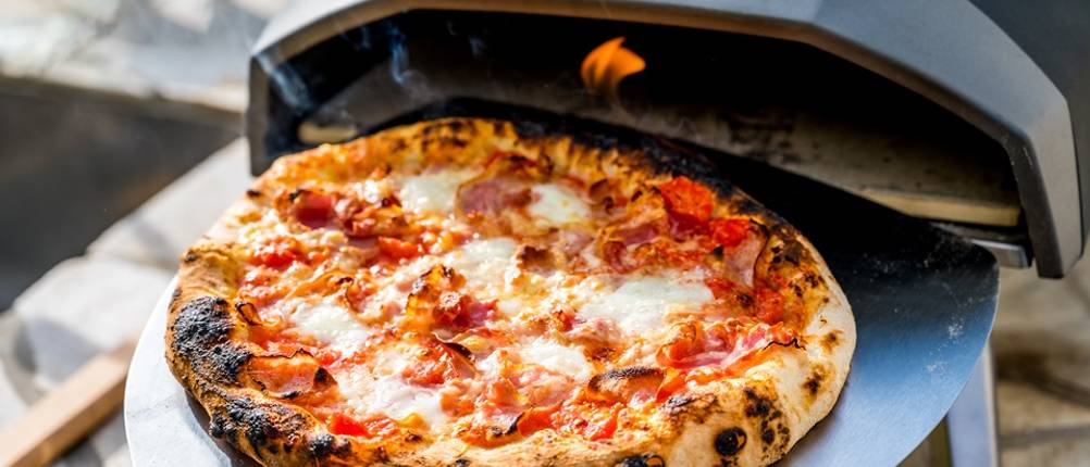 Pizzaofen im Test: Frisch gebackene Pizza kommt aus einem mobilen Pizzaofen.