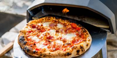 Pizzaofen im Test: Frisch gebackene Pizza kommt aus einem mobilen Pizzaofen.