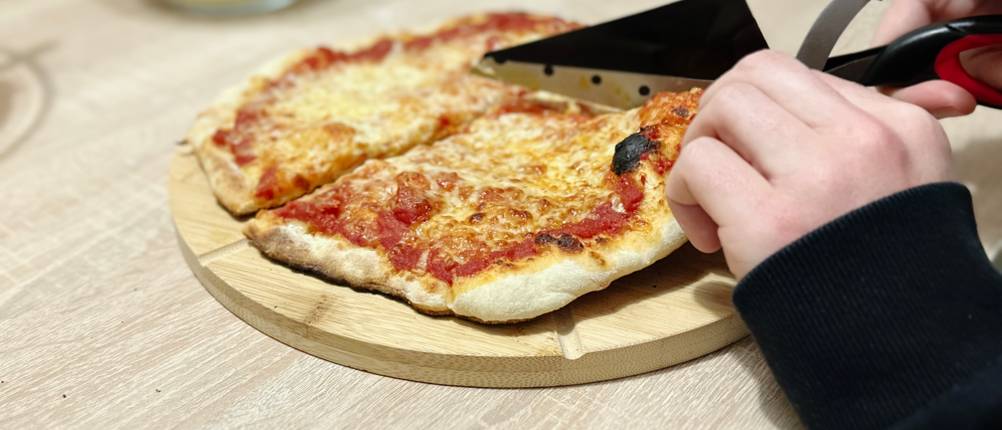 Mit der Pizzaschere von Asdirne wird eine Pizza geschnitten.