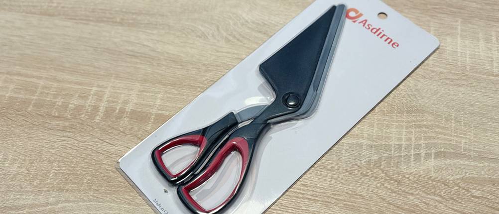 Die Pizzaschere von Asdirne liegt eingepackt auf einem Holztisch.