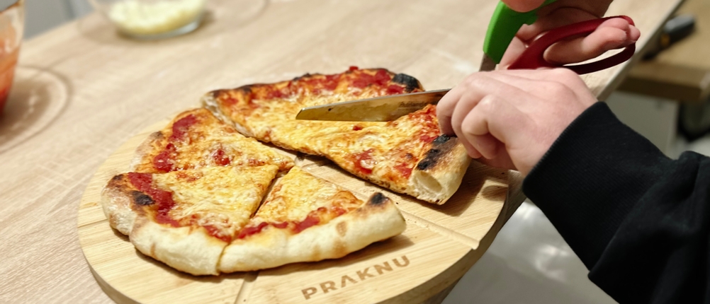 Mit der Pizzaschere von Triangle wird eine Pizza geschnitten.