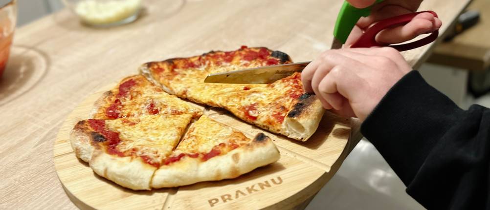 Mit der Pizzaschere von Triangle wird eine Pizza geschnitten.