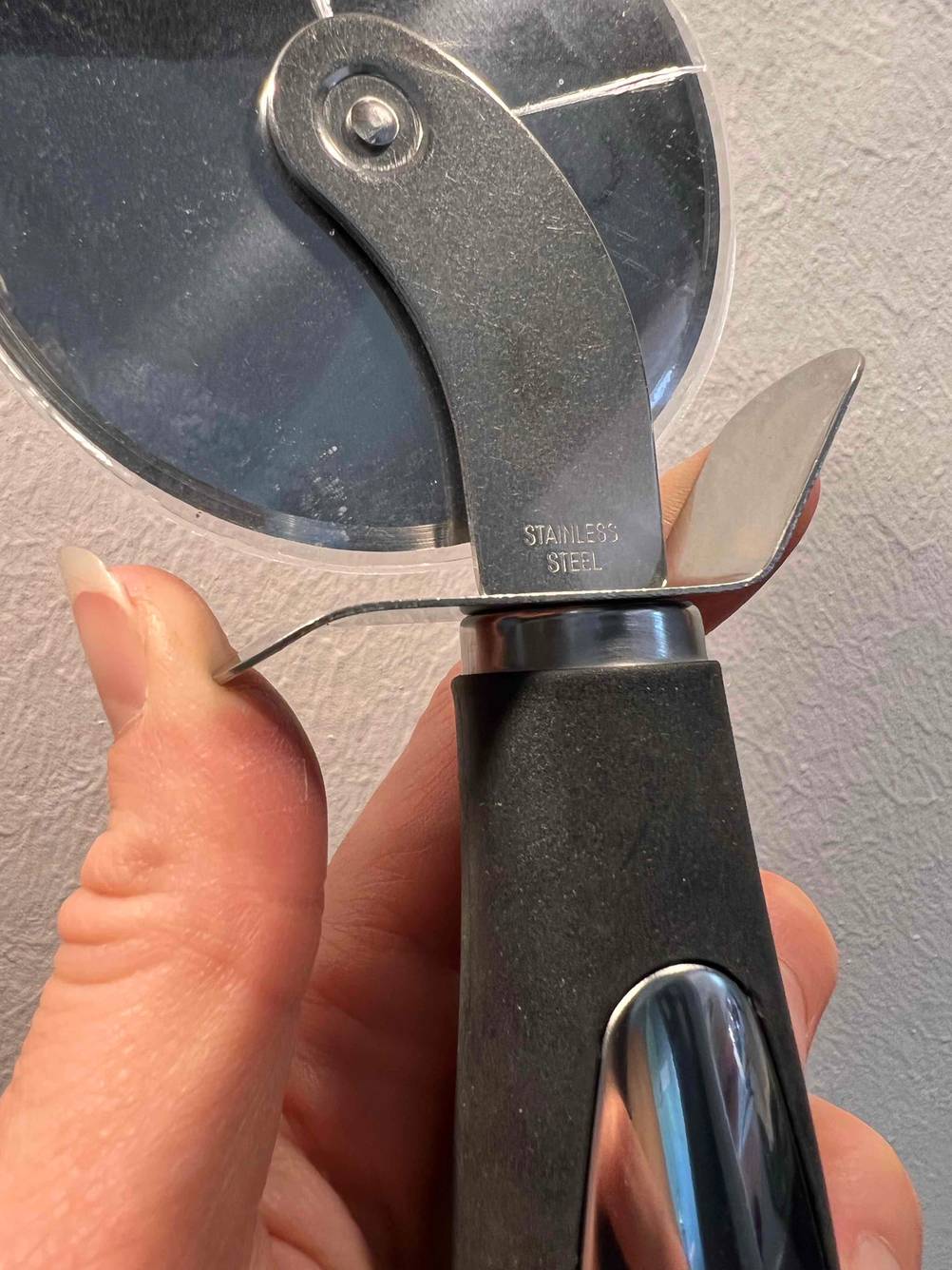 Nahaufnahme der Prägung 'Stainless Steel' eines getesteten Pizzaschneiders.