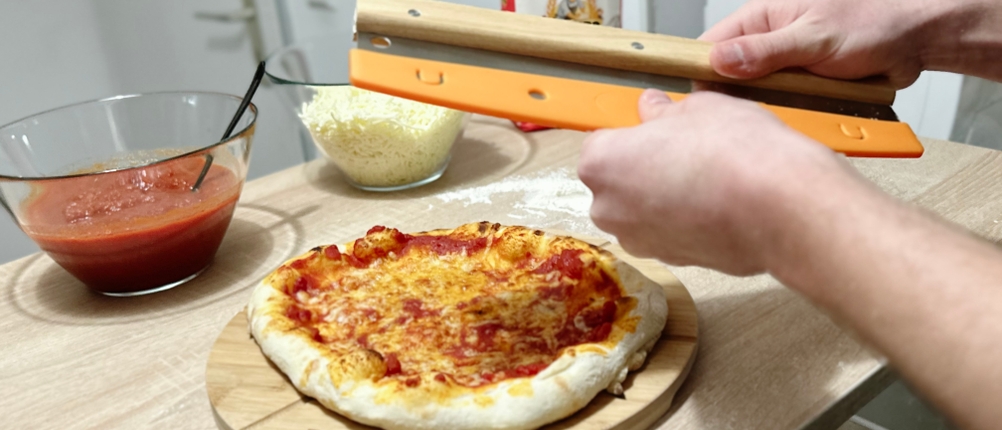 Die Abdeckung wird vom Pizzaschneider von Pizza Mondo entfernt.