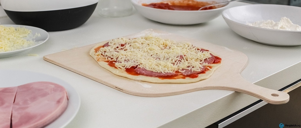 Pizzastein im Test: Belegte Pizza auf Holzbrett.