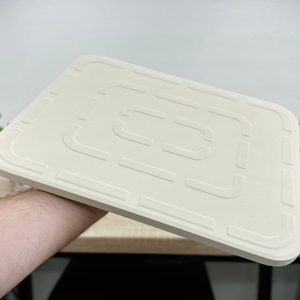 Die Unterseite des Pizzasteins von Blumtal zeigt ein geometrisches Muster. Der Stein wird von einer Hand getragen.