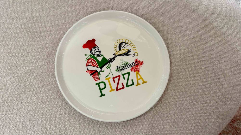 Ein getesteter Pizzateller auf einer hellen Stofffläche.