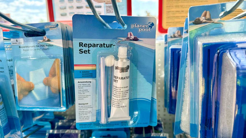Im Test: Mehrere Packungen Pool-Reparaturset hängen hintereinander zwischen anderen Produkten in einem Hängeregal.
