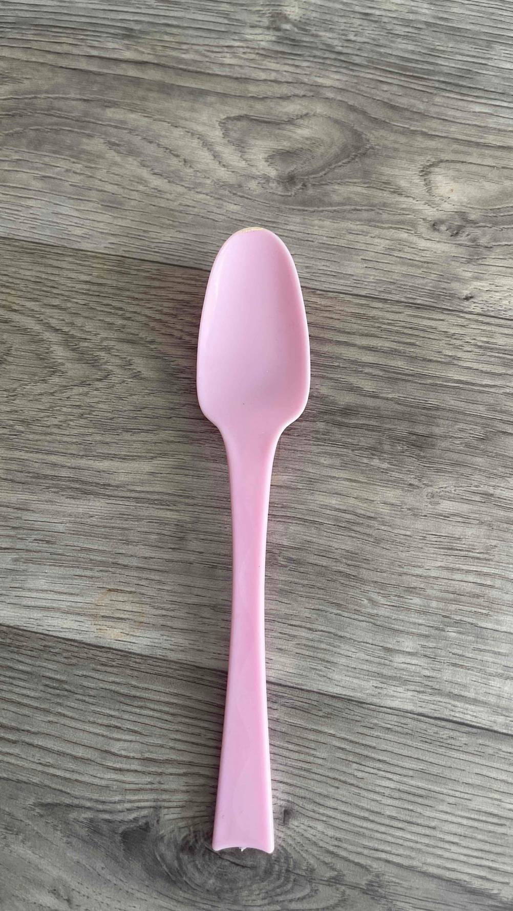 Auf einer Holzfläche liegt ein Plastiklöffel im Test.