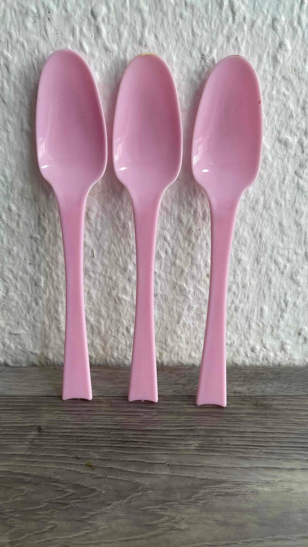 Drei der getesteten Plastiklöffel lehnen an einer Wand.