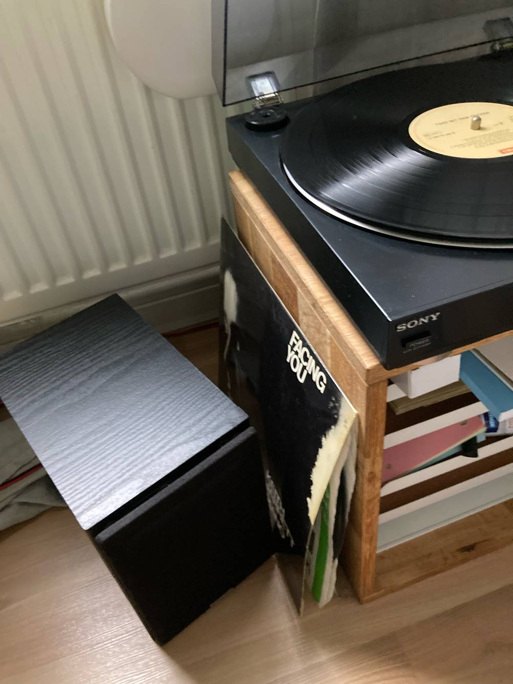 Blick von oben auf einen getesteten Plattenspieler mit Lautsprecher, dazwischen steht die Hülle der aufgelegten LP.
