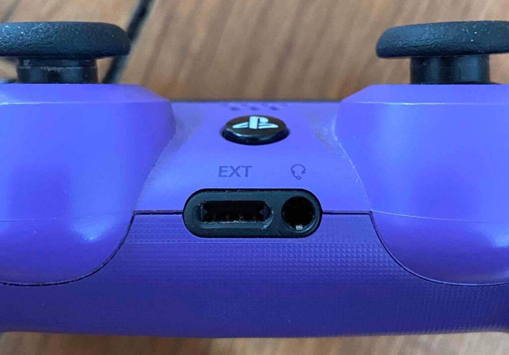Detailansicht der Verbindungsanschlüsse an einem lilafarbenen PS4-Controller im Test.