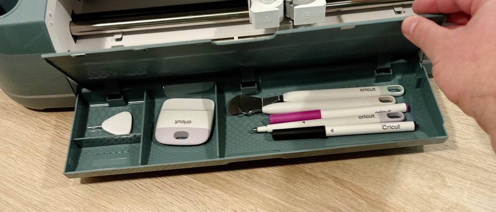 In der Klappe des Cricut-Plotters findet das mitgelieferte Werkzeug und Zubehör Platz.