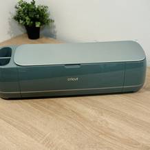 Der Plotter von Cricut steht auf einem Holztisch.